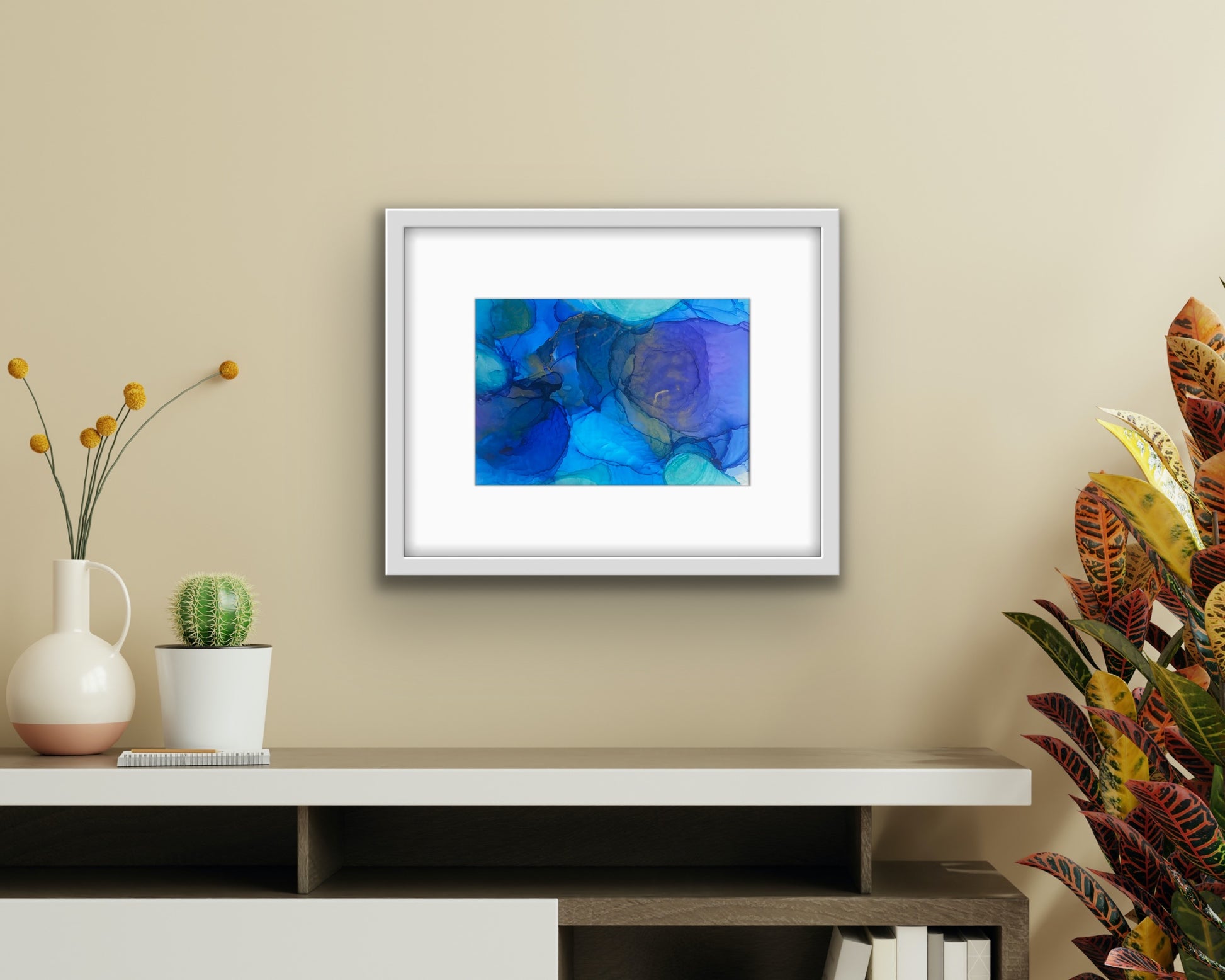 Blue Drift by Ludwina Orchard – alcohol ink painting on polypropylene displayed in a modern boho-style room with a low shelf, cactus and tropical plant