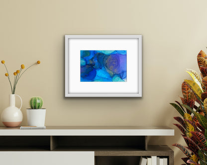 Blue Drift by Ludwina Orchard – alcohol ink painting on polypropylene displayed in a modern boho-style room with a low shelf, cactus and tropical plant