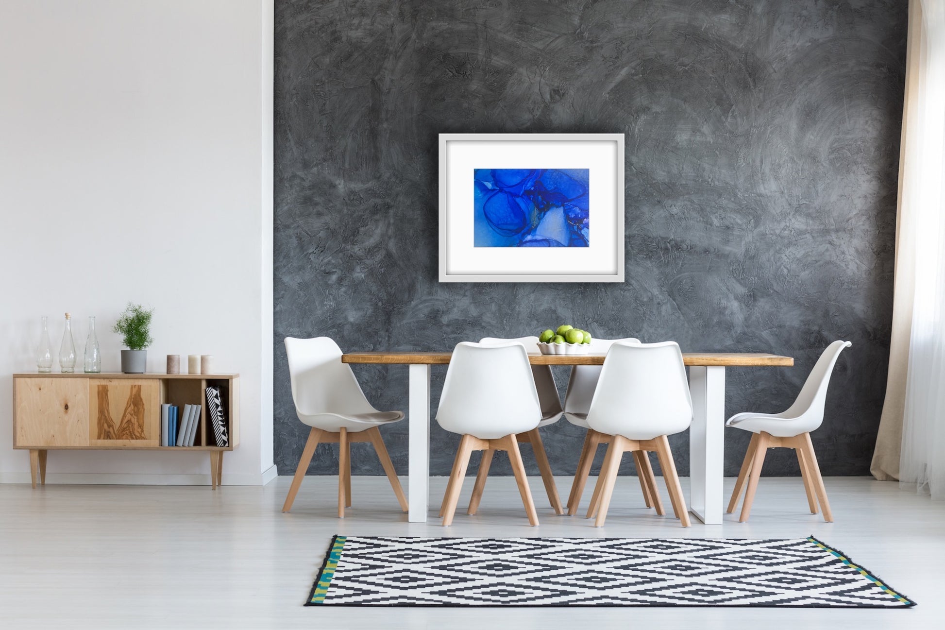 Blue Drift by Ludwina Orchard – alcohol ink painting on polypropylene displayed in a Scandinavian dining room with white chairs and wooden table against dark grey concrete wall