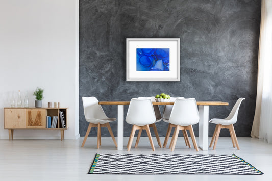 Blue Drift by Ludwina Orchard – alcohol ink painting on polypropylene displayed in a Scandinavian dining room with white chairs and wooden table against dark grey concrete wall
