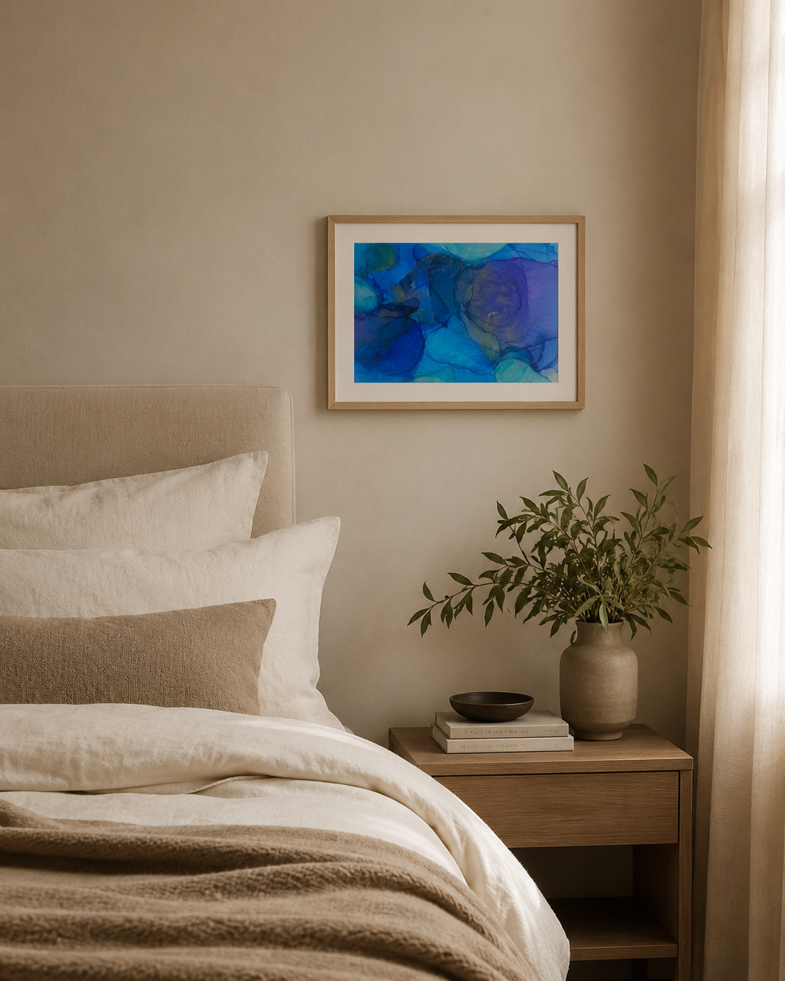 Cerulean by Ludwina Orchard – alcohol ink painting displayed in a cosy bedroom with white linen bedding and a wooden nightstand with greenery