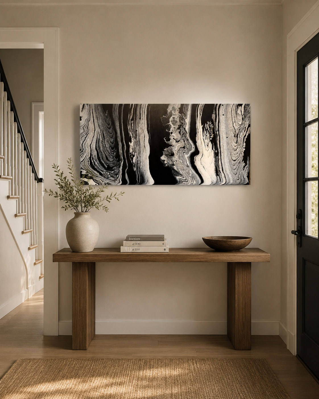 Wisdom by Ludwina Orchard – ring-poured acrylic painting with black, white and grey swirling forms displayed above a wooden console table in an entryway