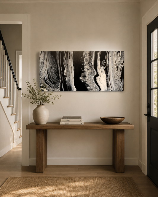 Wisdom by Ludwina Orchard – ring-poured acrylic painting with black, white and grey swirling forms displayed above a wooden console table in an entryway